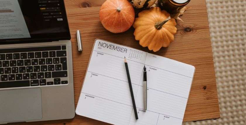 pumpkins and a digital planner on wooden desk for passive income