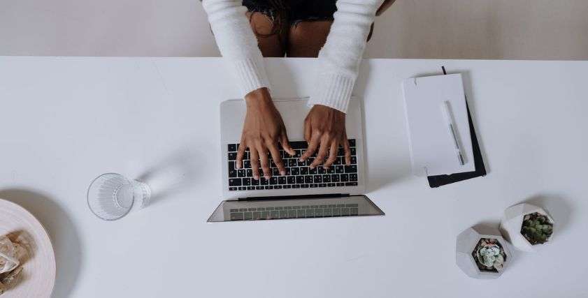 woman in white long sleeve shirt using macbook pro